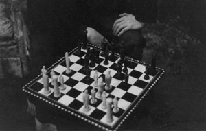 a picture of someone sitting at the corner while playing chess